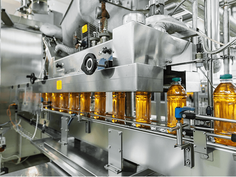 Bottling equipment fills containers with cooking oil 