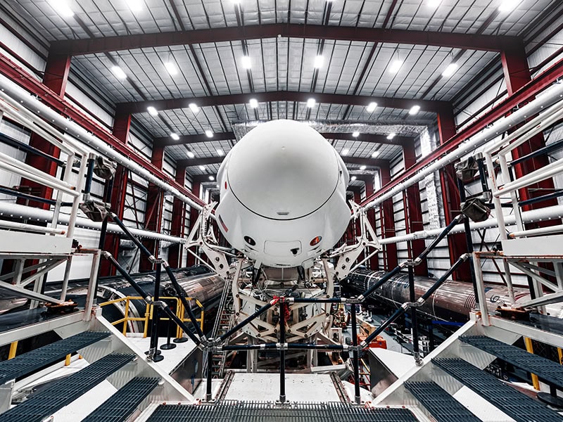 High-tech aerospace manufacturing facility with advanced spacecraft assembly in a spacious industrial environment for satellite and space exploration projects.