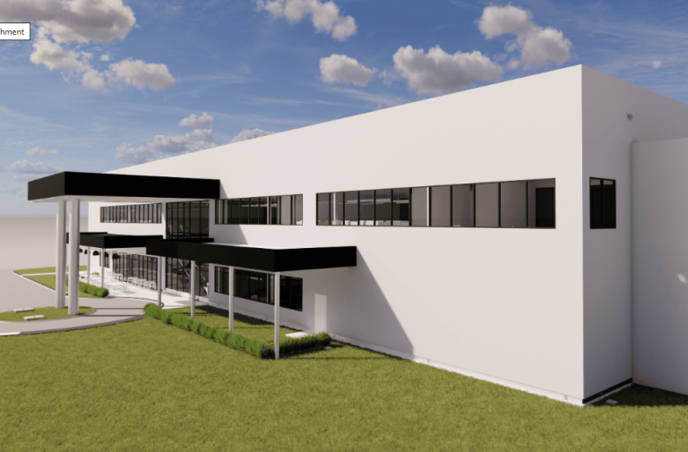 Contemporary white commercial building with black accents, large windows, and a landscaped lawn under a partly cloudy sky, showcasing modern architecture.