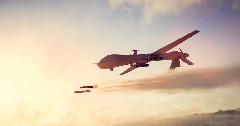 Military drone flying at sunset with missile payloads, showcasing advanced warfighting technology from MWS Wire.